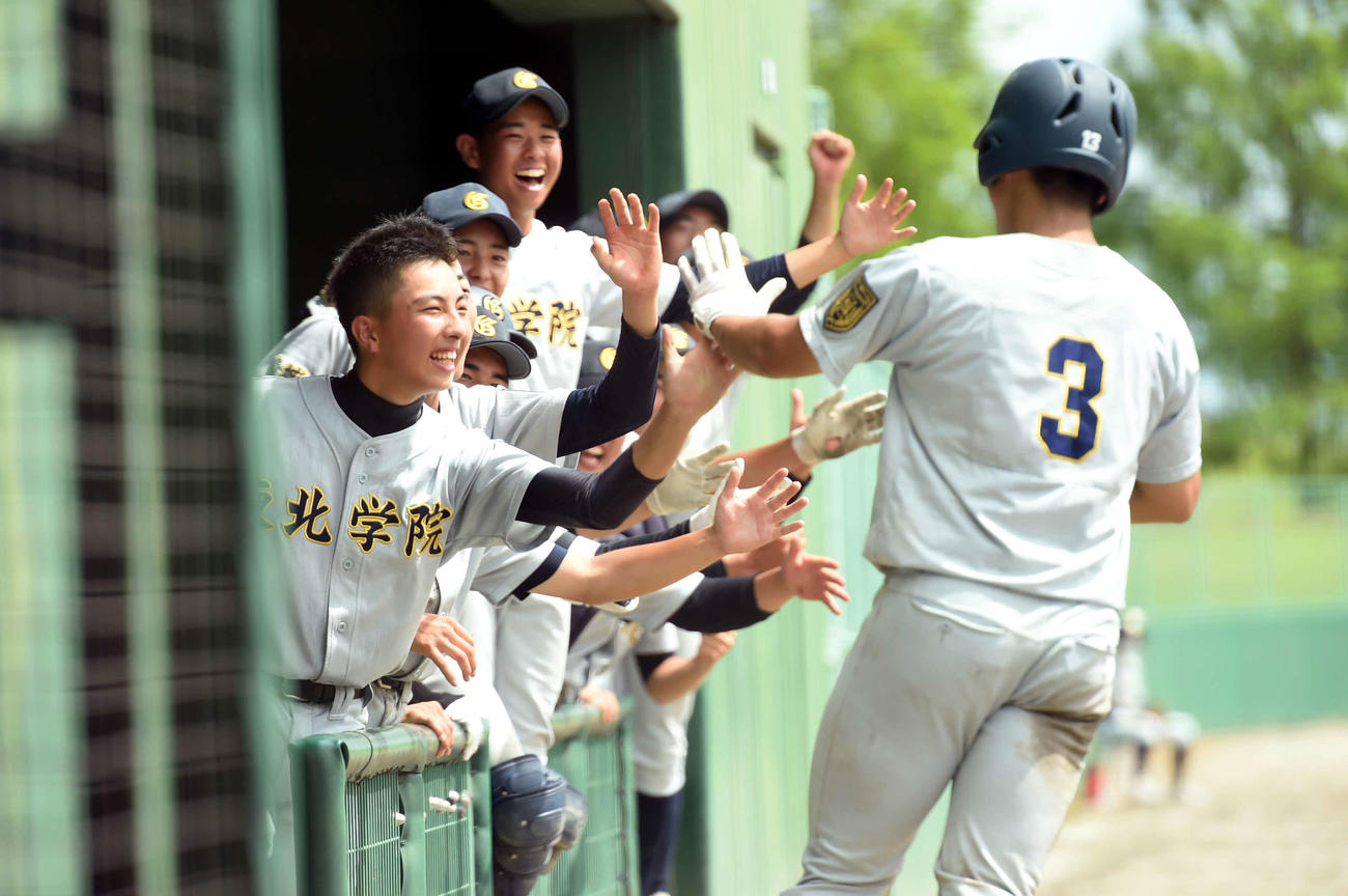 東北学院対古川工　8回、2点本塁打を放った東北学院・佐藤雅（右）を祝福するナイン（撮影・相沢孔志）