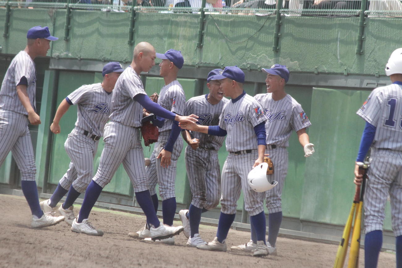 須磨翔風・槙野時斗投手は延長10回のピンチを切り抜け、ベンチで仲間とハイタッチ