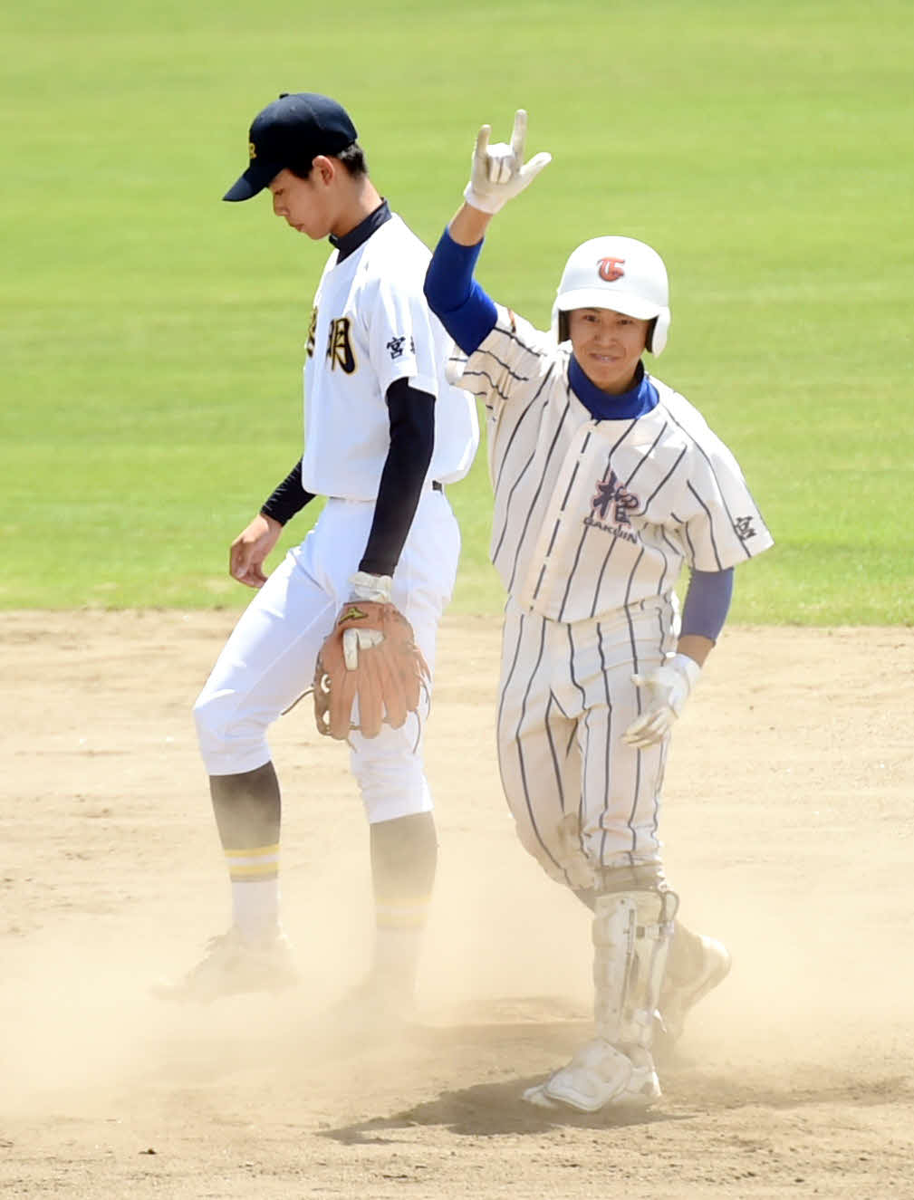 古川黎明対東北学院榴ケ岡　1回裏、先制適時打を放ち、塁上で笑顔を見せる難波（右）（撮影・相沢孔志）