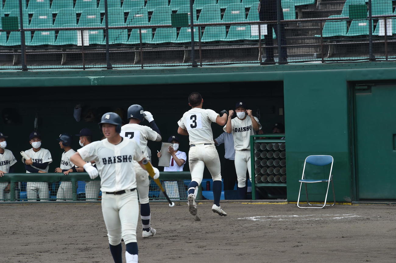 ソロ本塁打を放った大分商・福田紘史内野手（右から2人目）と迎える同校・長吉勇典監督（右）
