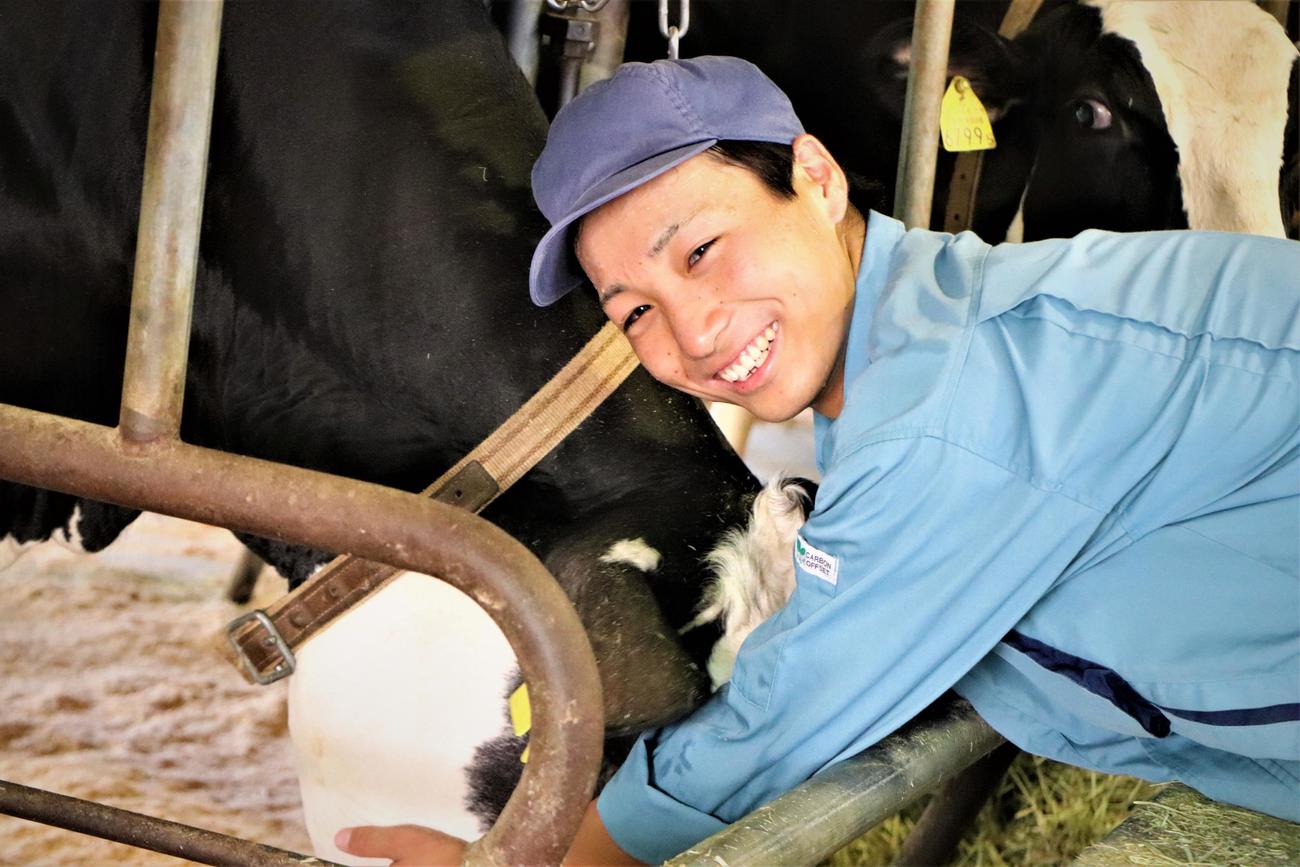 管理する牛をなでて笑顔を見せる瑞穂農芸・石井（撮影・藤塚大輔）