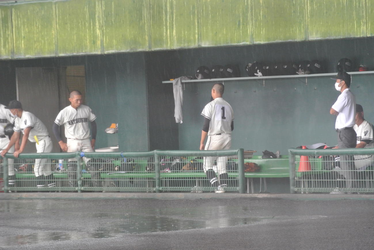 長野大会初の継続試合が決まり、松商学園のエース栗原英豊投手（3年）は激しい雨で瞬く間に水たまりができたグラウンドを横目にベンチを移動する