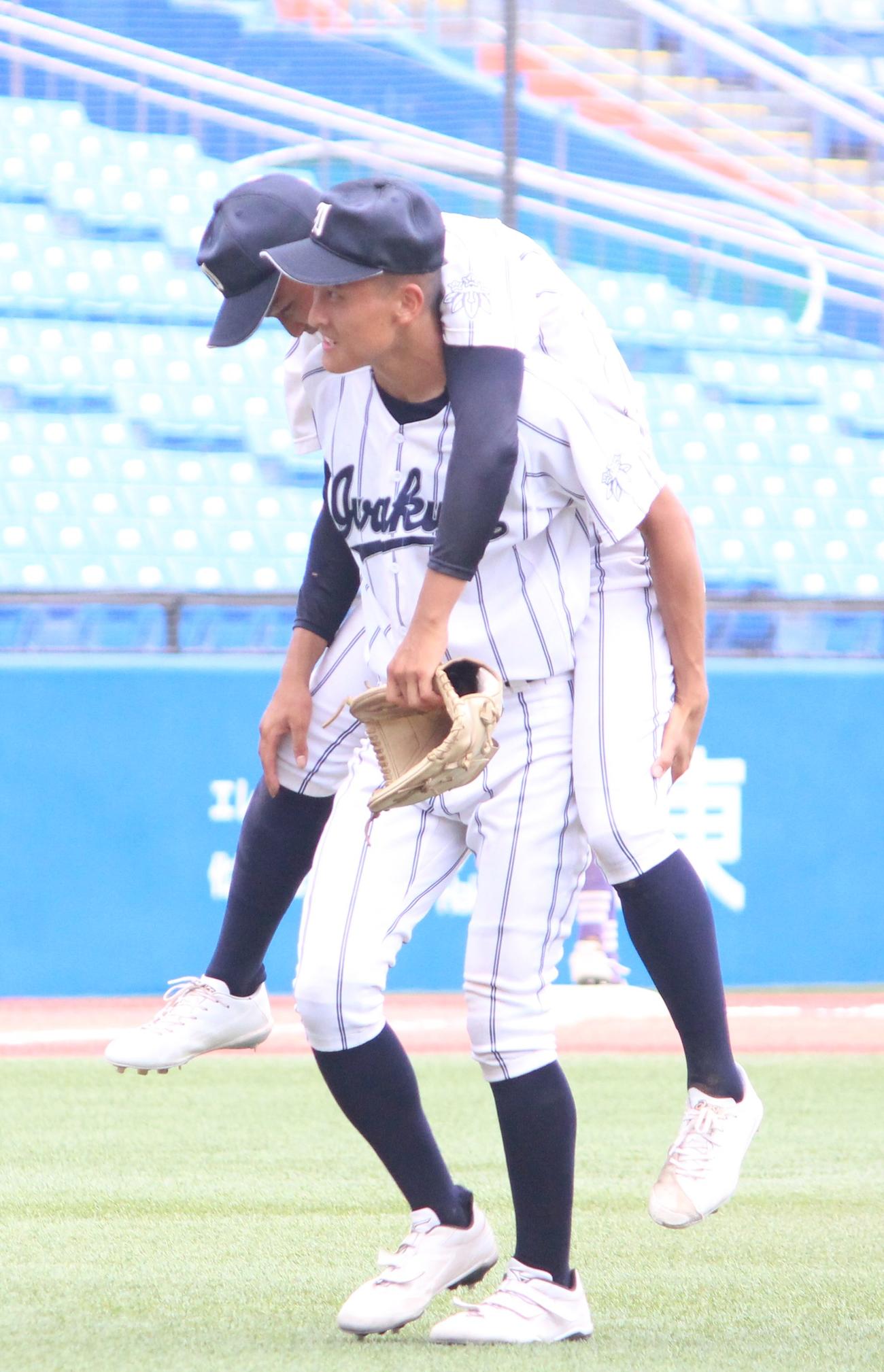 文京対岩倉　7回途中で足をつり、背負われて交代する岩倉・徳元（上）（撮影・保坂恭子）
