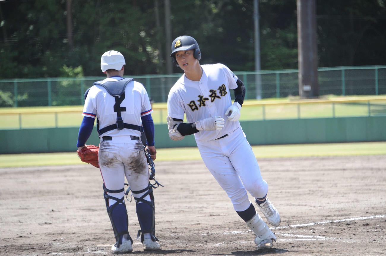 コールド勝ちを決める満塁本塁打を放ち、悠々と生還する日本文理・田中