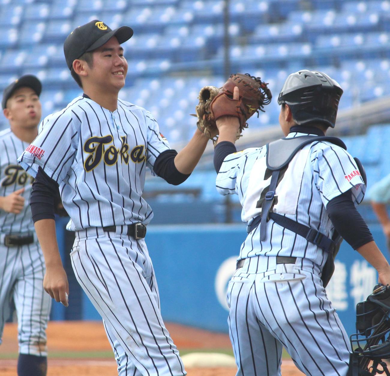駿台学園対東海大高輪台　完封勝利を挙げ、バッテリーでハイタッチをする東海大高輪台・石川（左）（撮影・保坂恭子）