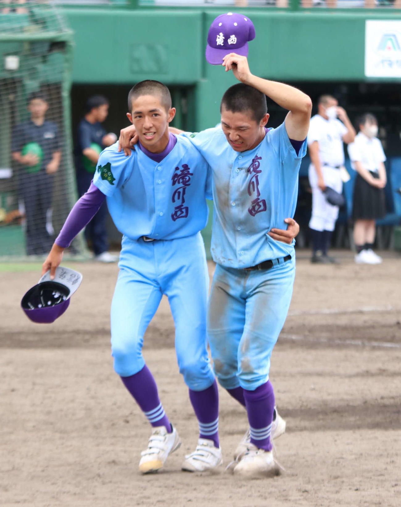 あいさつを終え、チームメートに支えられながらベンチへと向かう岩崎主将（右）（撮影・山崎純一）