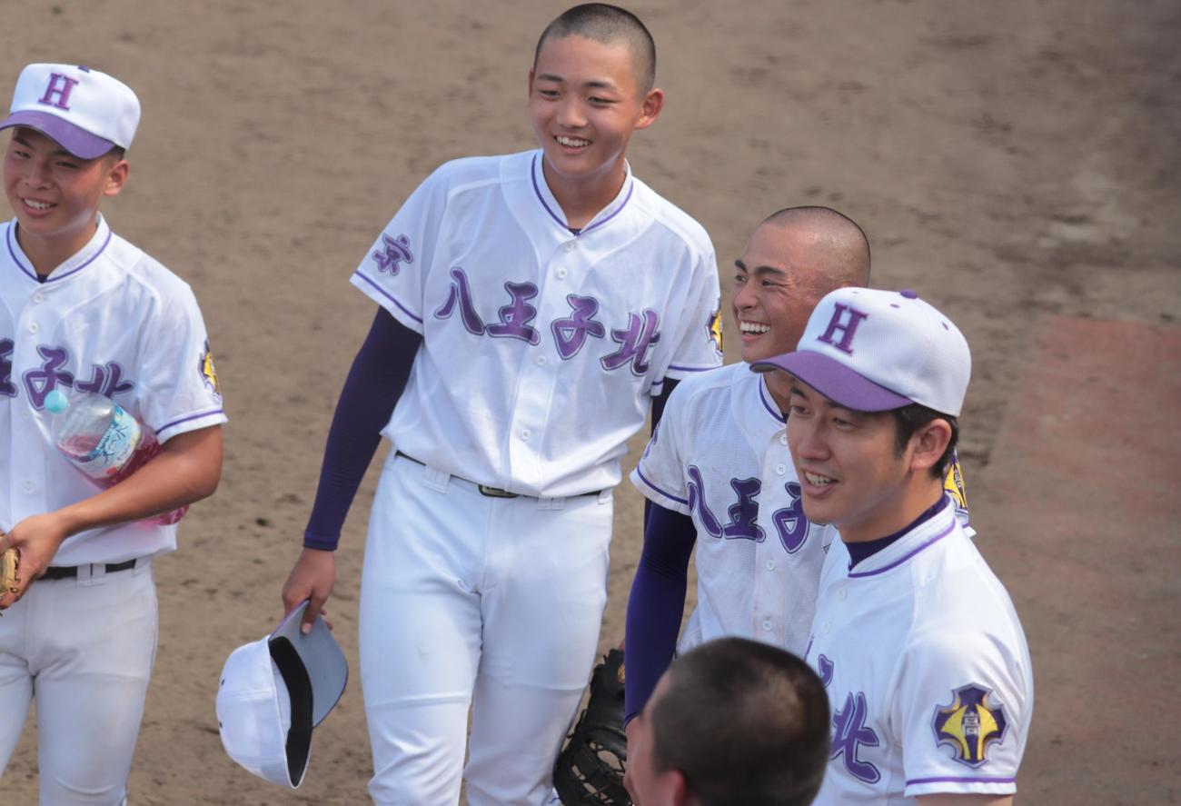 八王子北対武蔵野北　イニングの間に笑顔で選手に話しかける武蔵野北・内田監督（撮影・藤塚大輔）