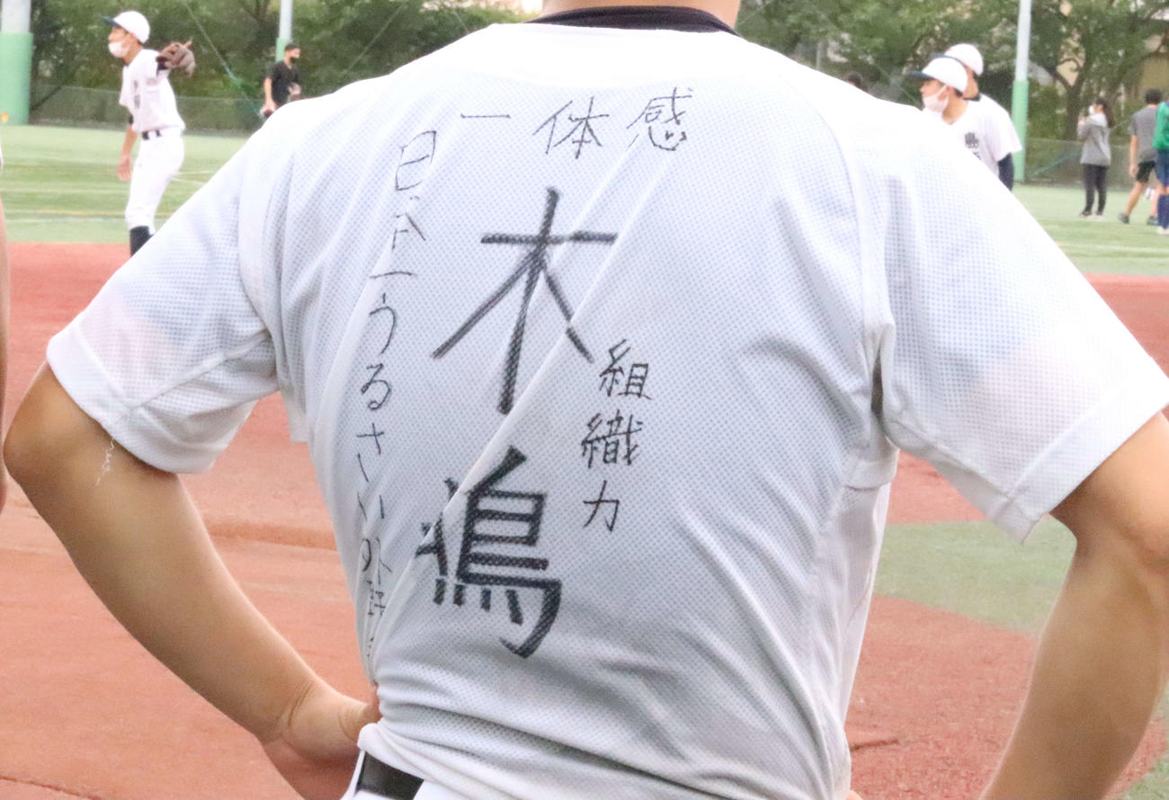 「日本一うるさい外野手」と書かれた練習着を身につける日大鶴ケ丘の選手（撮影・藤塚大輔）