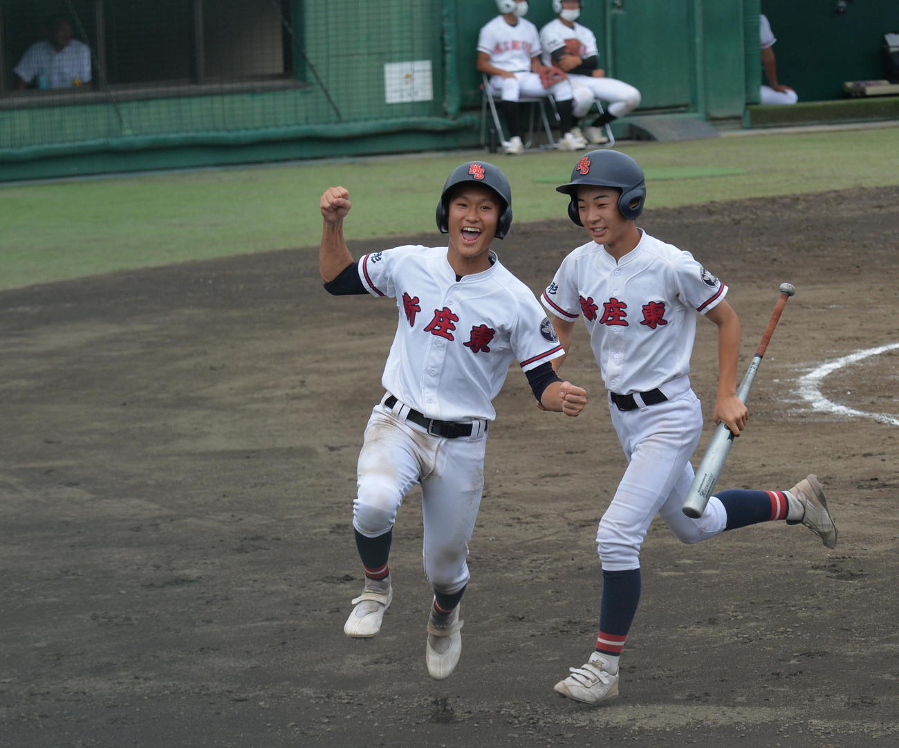 新庄東対日大山形　9回、2点適時打を放った新庄東・須藤（左）は、自身も生還しガッツポーズ