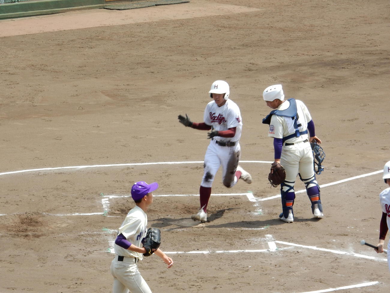 八丈－堀越　2回表2死二塁、八丈は加藤聖外野手の二塁打で二塁走者の菊池明博一塁手が手をたたいて生還、同点に追いついた
