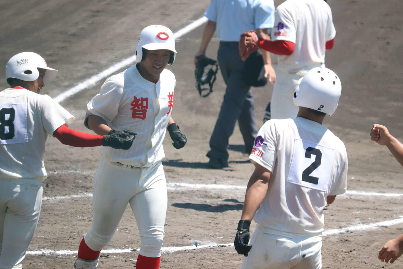 3回戦、向陽戦で3回に先制の満塁本塁打を放ち笑顔で仲間に迎えられる智弁和歌山・岡西佑弥（写真中央）（撮影・波部俊之介）＝2022年7月22日、和歌山・紀三井寺運動公園野球場