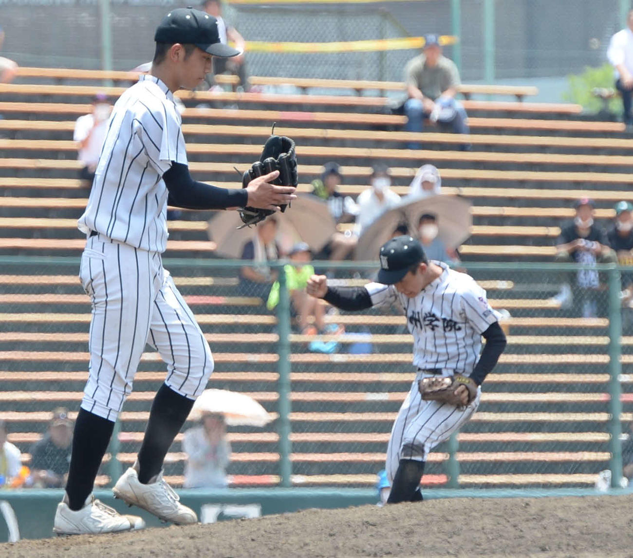 九州学院対秀岳館　8回2死一、三塁のピンチを無失点に抑え、九州学院・直江（左）は手をたたく（撮影・只松憲）