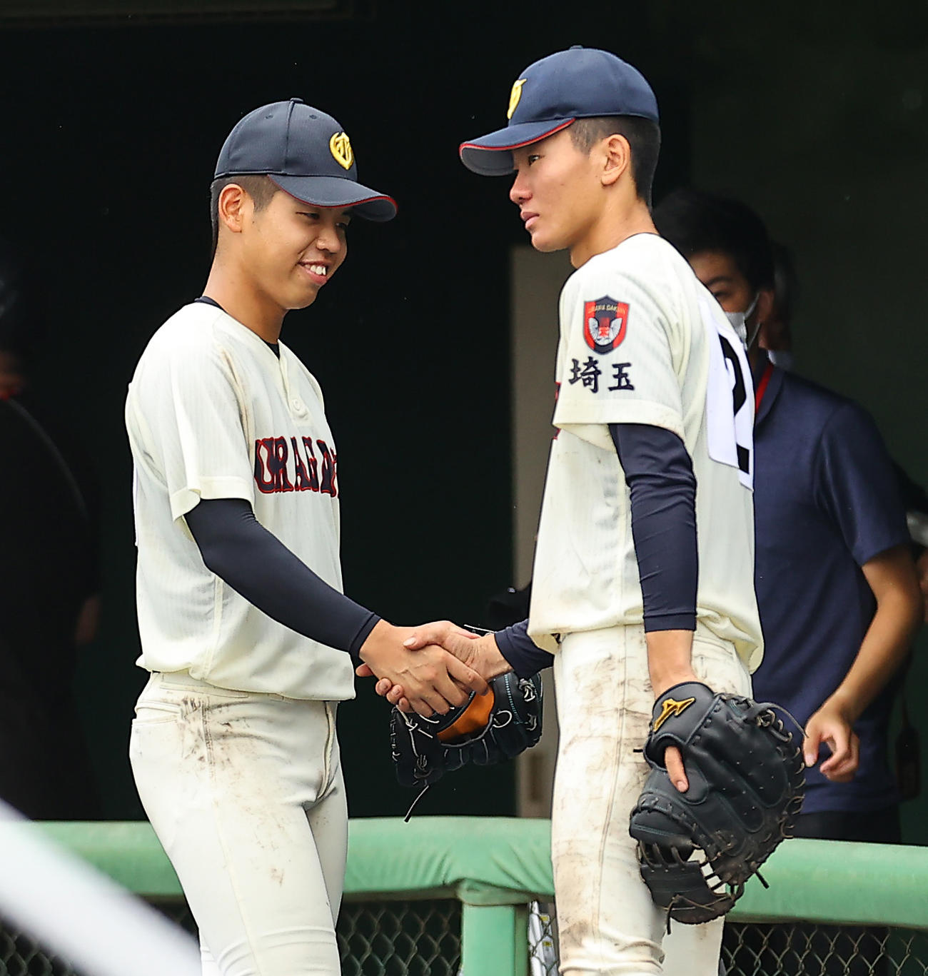 試合に敗れ最後のクールダウンを終えた浦和学院・宮城（左）は涙をにじませる高山と笑顔で握手を交わす（撮影・垰建太）
