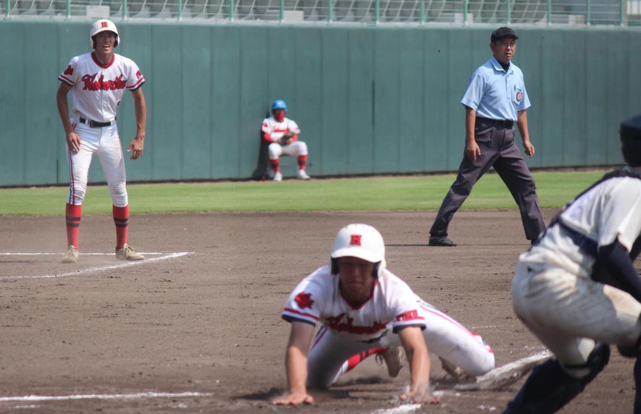 北陸対若狭　3回表、ホームに頭から飛び込む北陸・矢納弘と三塁コーチの双子の兄、矢納圭（撮影・柏原誠）