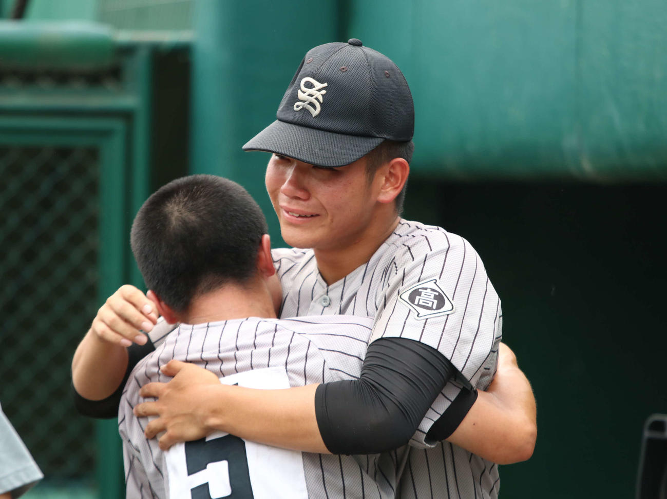 札幌大谷対知内　試合後、泣きながらベンチ前でチームメートと健闘をたたえ合う知内・坂本（撮影・山崎純一）