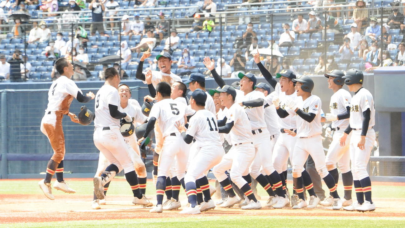 サヨナラ打を放った田中（左から2人目）をホームで迎え入れる日本文理の選手