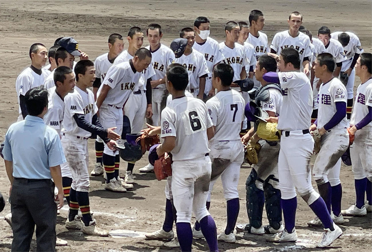 試合を終え、健闘をたたえ合う生駒（左側）と天理の選手たち（共同）