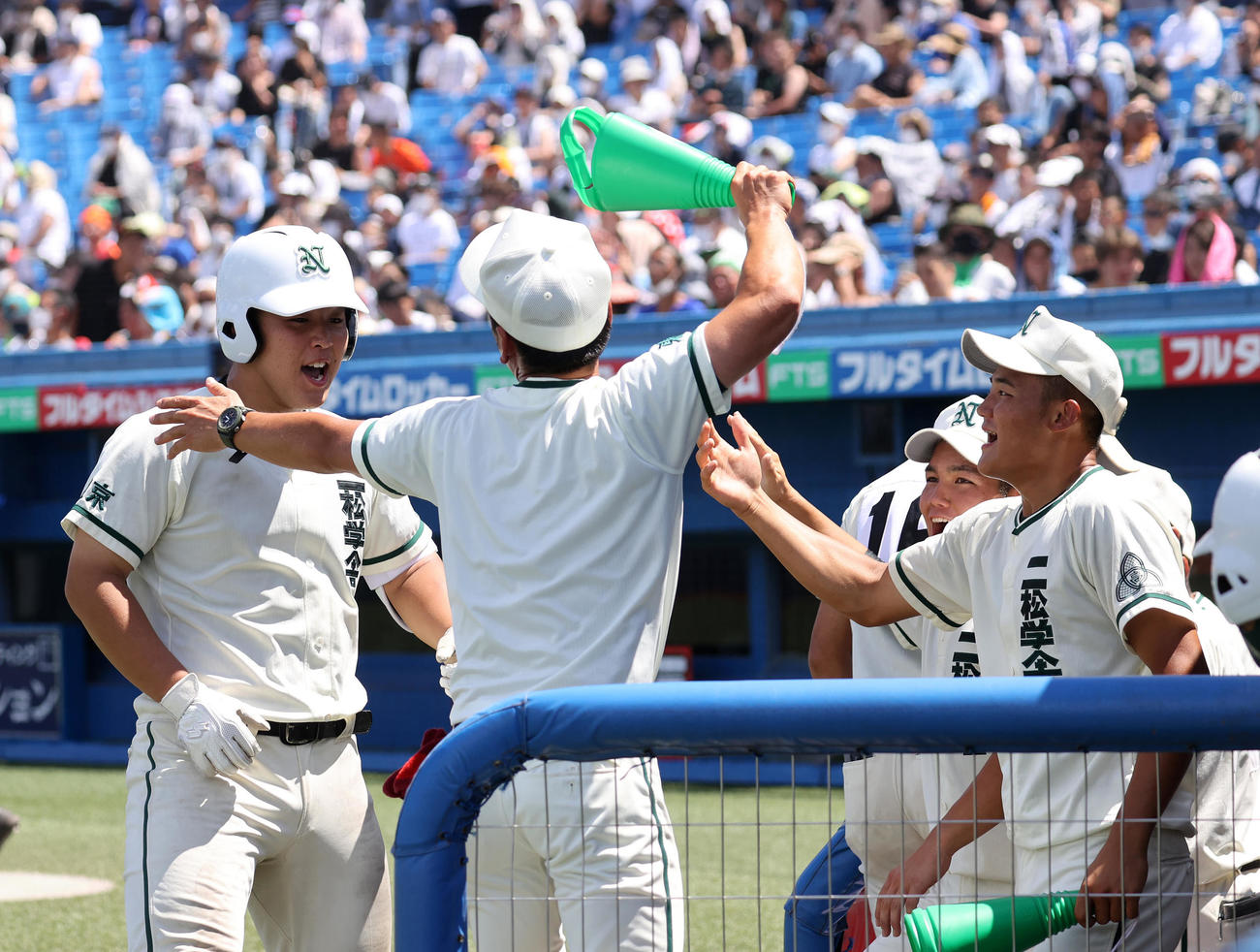 帝京対二松学舎大付　3回裏二松学舎大付2死、片井（左）は左越え本塁打を放ちコーチにメガホンで祝福される（撮影・鈴木正人）