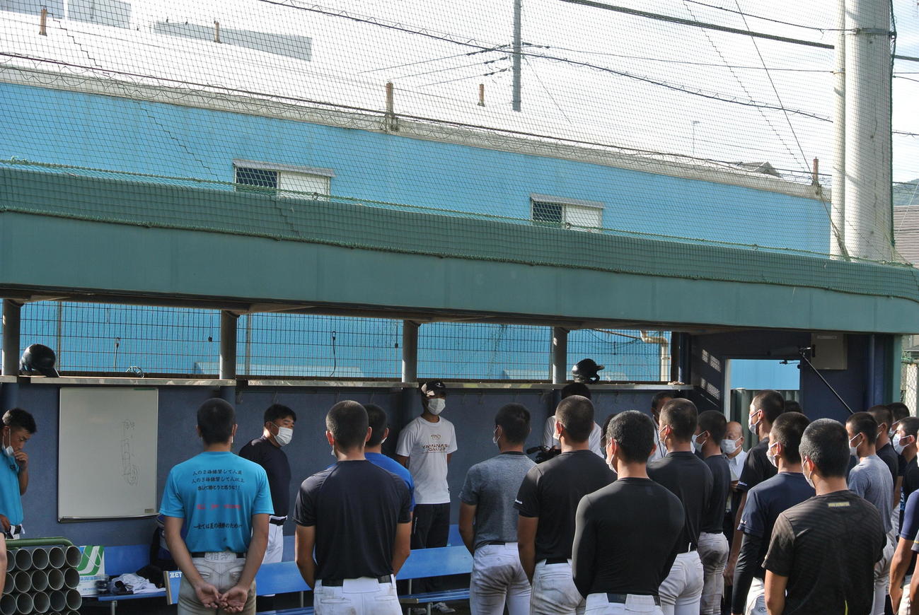 山梨学院の甲子園大会のベンチ入りメンバー18人が発表する吉田洸二監督（左から3人目）