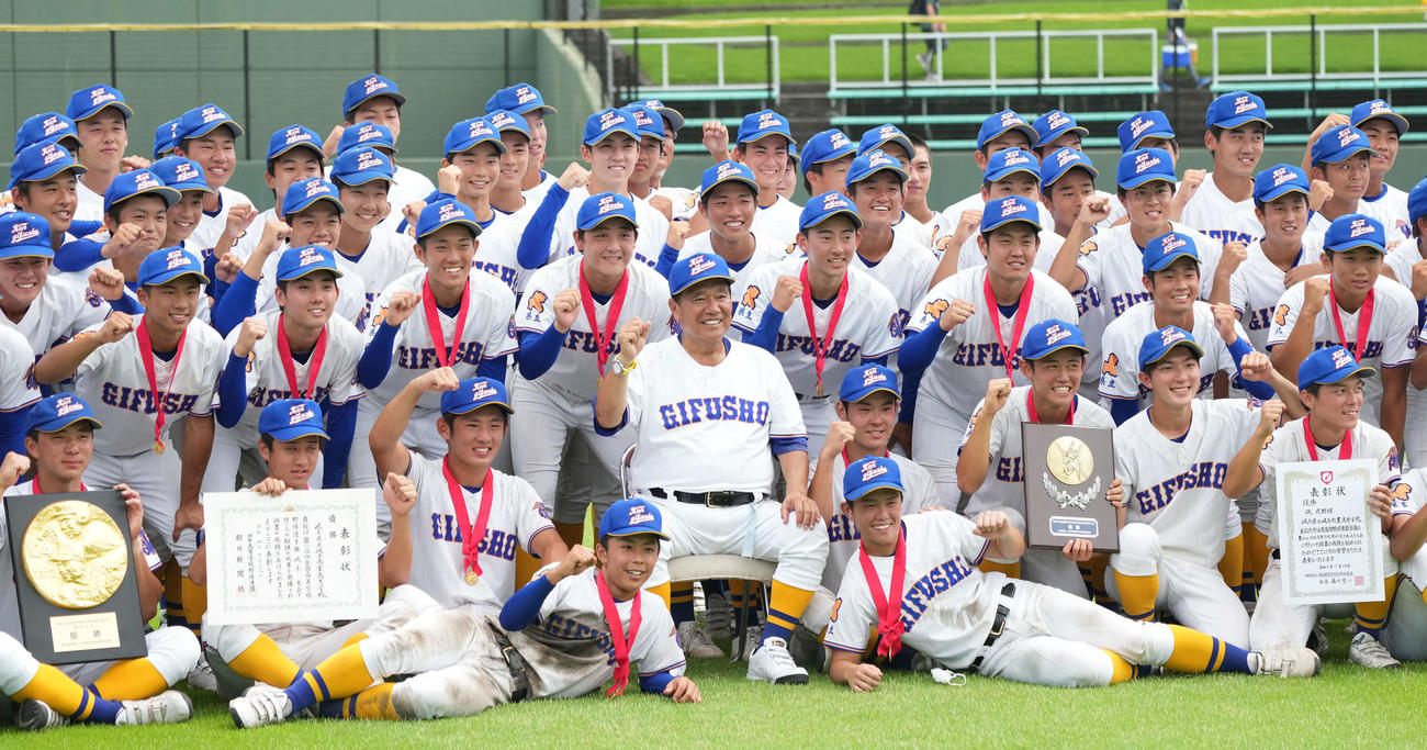 岐阜大会を優勝し笑顔でナインと記念撮影をする県立岐阜商・鍛治舎巧監督（中央）（撮影・森本幸一）