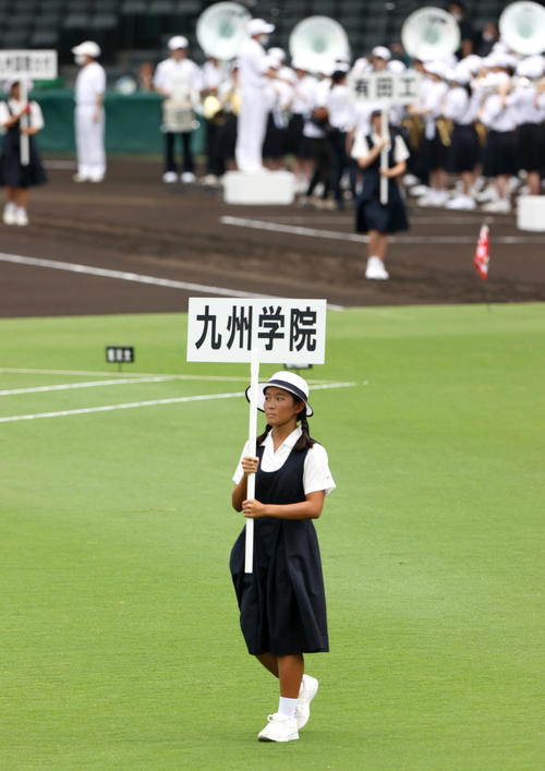 九州学院のプラカードを持ち行進する西宮市立西宮高校の女子生徒(撮影・上山淳一)