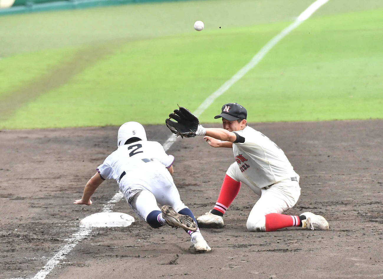 日大三島対国学院栃木　4回裏国学院栃木1死一、三塁、小垣のスクイズ空振りから帰塁する三塁走者の武田（左）のヘルメットに日大三島捕手の野田からの送球が当たり、国学院栃木が同点に追いつく（撮影・岩下翔太）