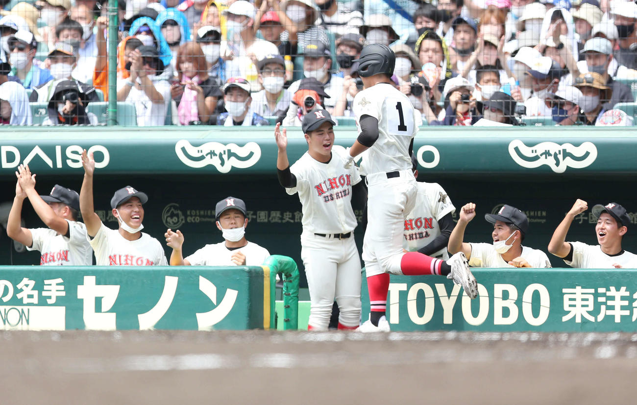 日大三島対国学院栃木　2回表日大三島無死三塁、野口の犠飛で生還しタッチで迎えられる松永（手前）（撮影・宮地輝）