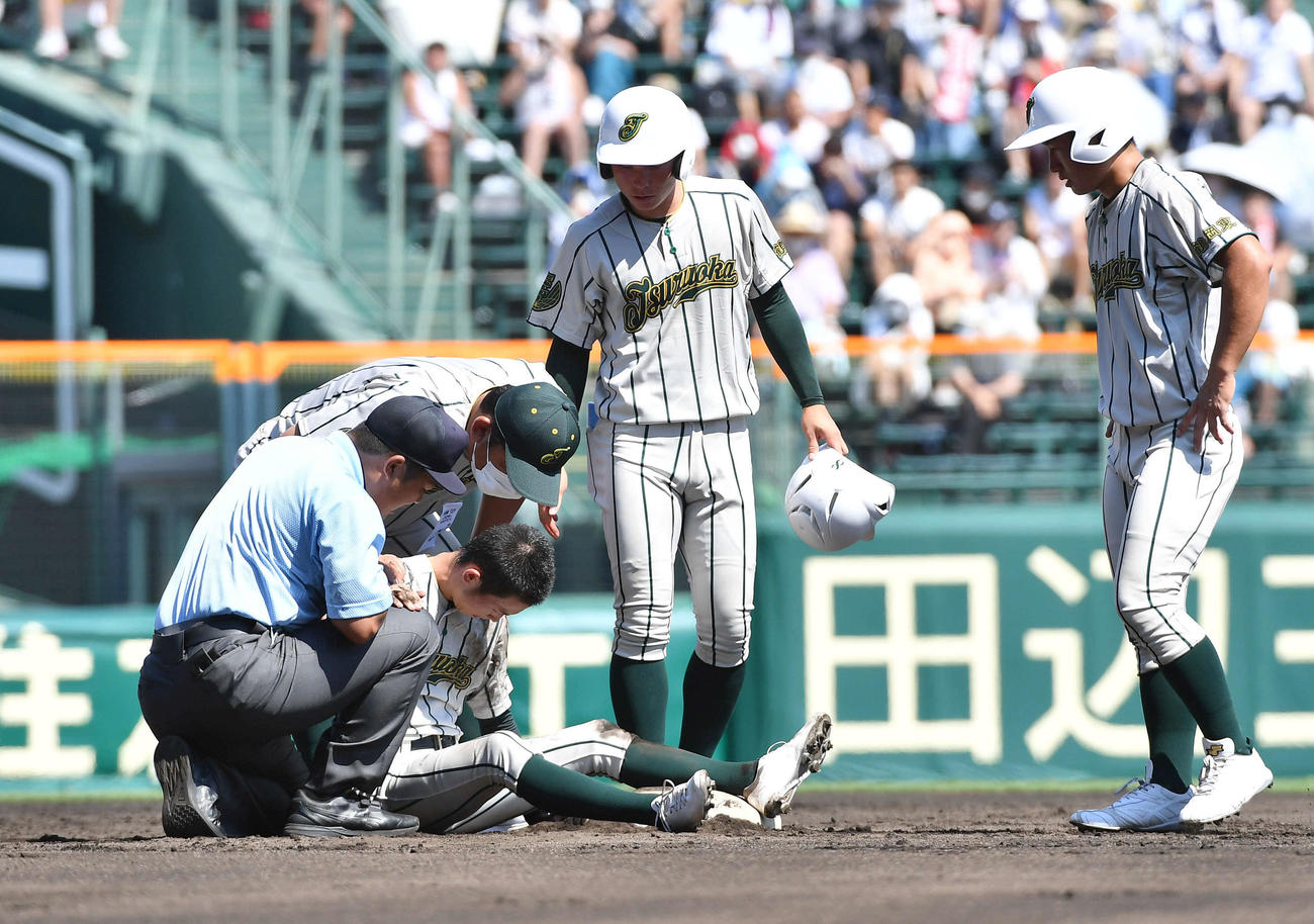 鶴岡東対盈進　1回表鶴岡東1死一、二塁、帰塁の際にボールが当たった武田（下）に心配そうに声をかける佐藤監督（撮影・岩下翔太）