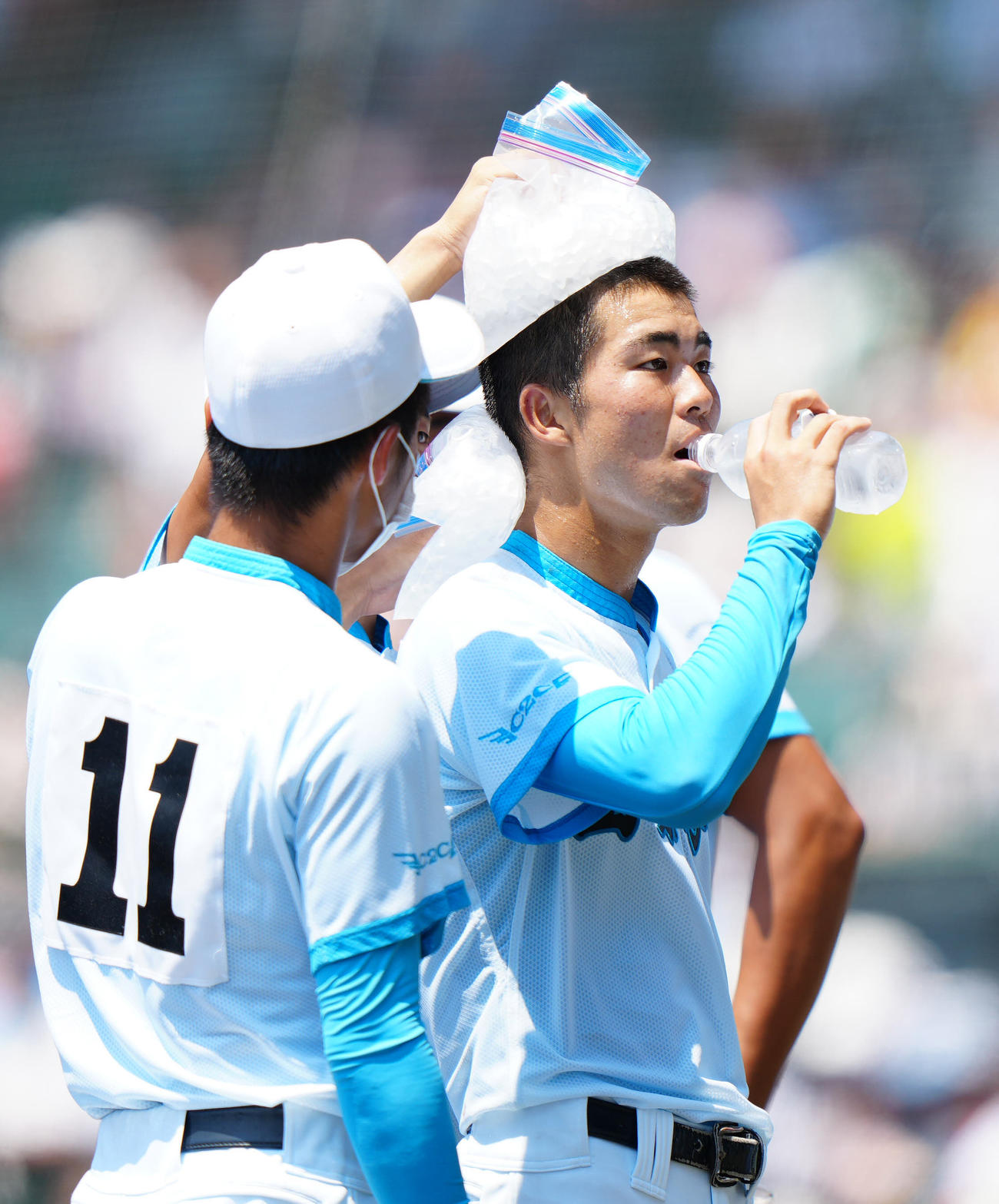 山梨学院対天理　5回表開始前、頭と首を氷で冷やしてもらう山梨学院先発の山田（撮影・江口和貴）