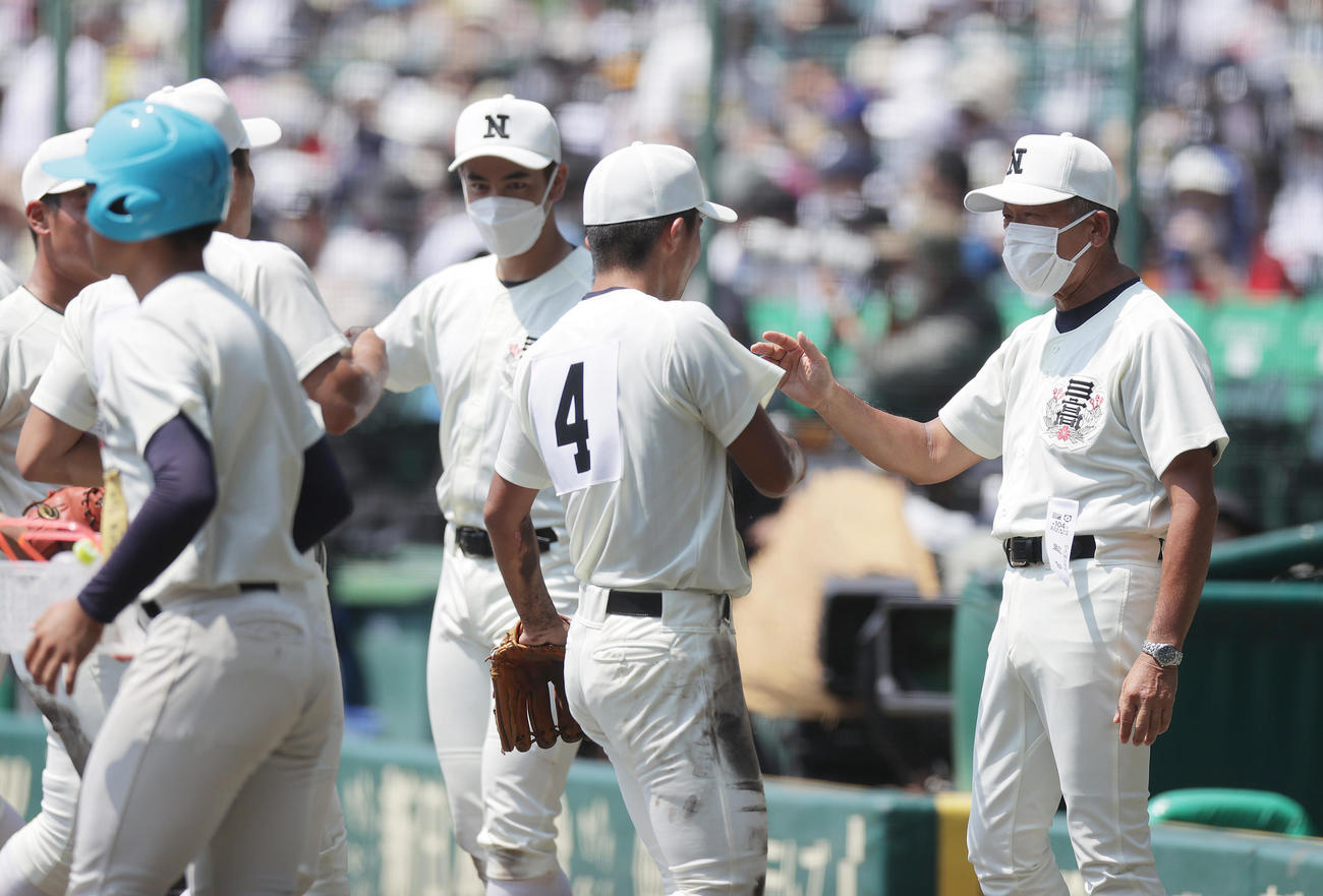 日大三対聖光学院　1回裏の守備を終えたナインを迎える日大三・小倉監督（右）（撮影・前田充）
