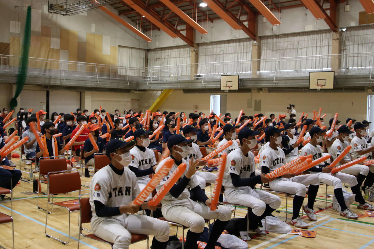 札幌大谷高体育館で設置された大型スクリーンを見ながら、選手たちを応援する生徒や保護者たち（撮影・山崎純一）