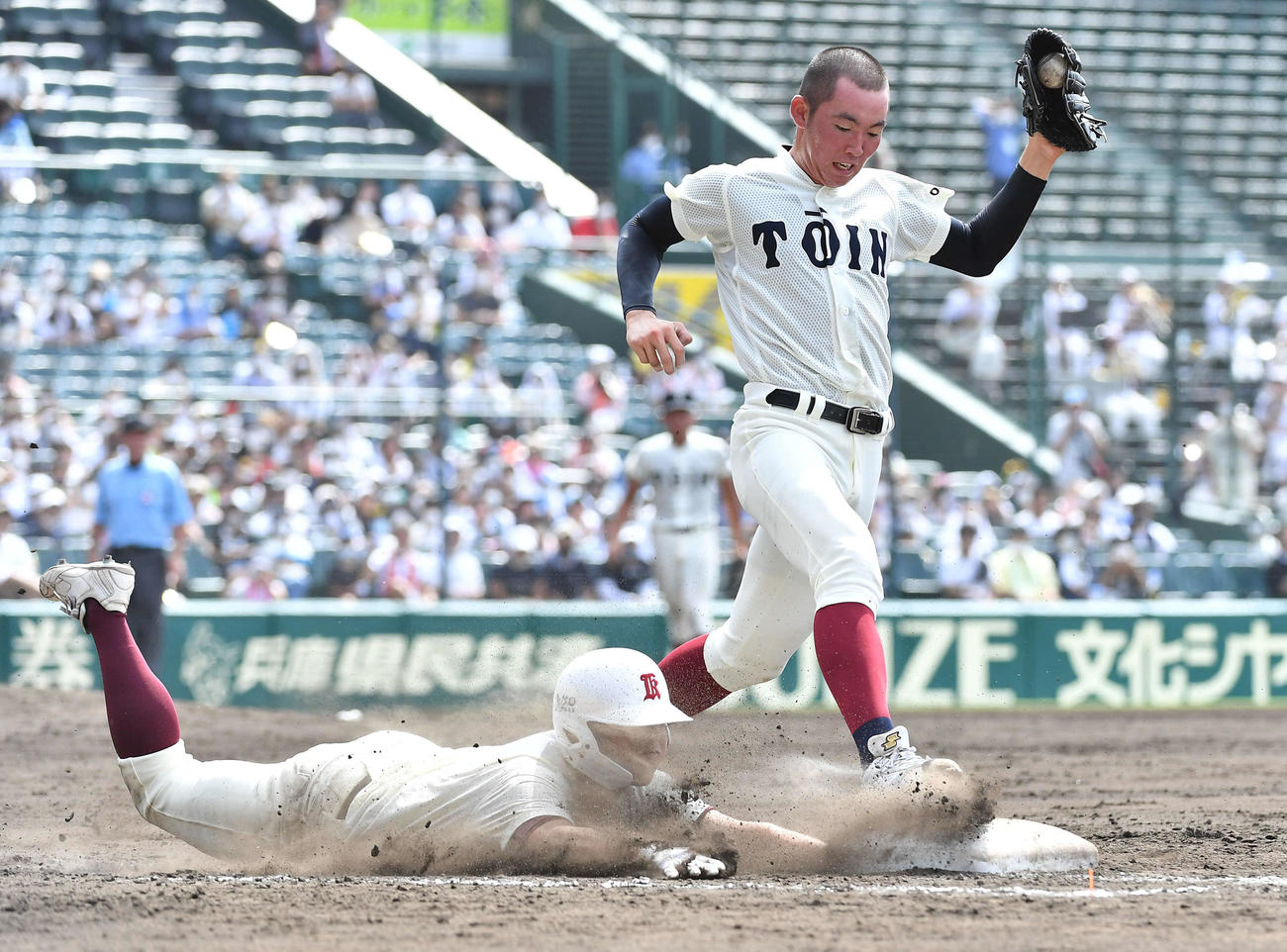 旭川大高対大阪桐蔭　9回表旭川大高2死一、二塁、一ゴロでベースカバーに入る大阪桐蔭別所（右）との競争でヘッドスライディングし、セーフとなる藤田（撮影・岩下翔太）