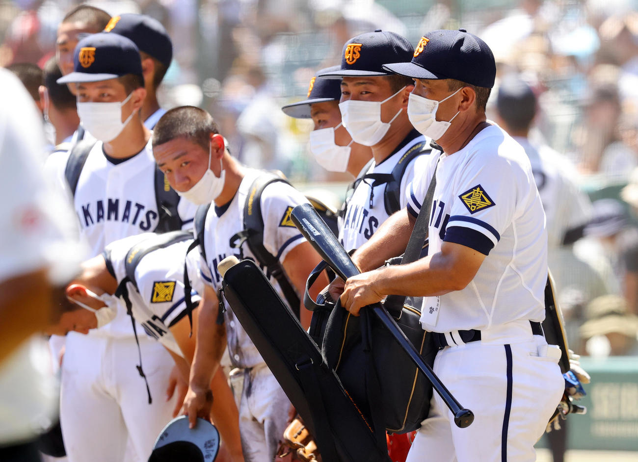 高松商対佐久長聖　14－4で勝利した高松商・長尾監督（右端）は、イチロー氏から贈られたバットを手に引き揚げる。右から2人目は浅野主将（撮影・野上伸悟）