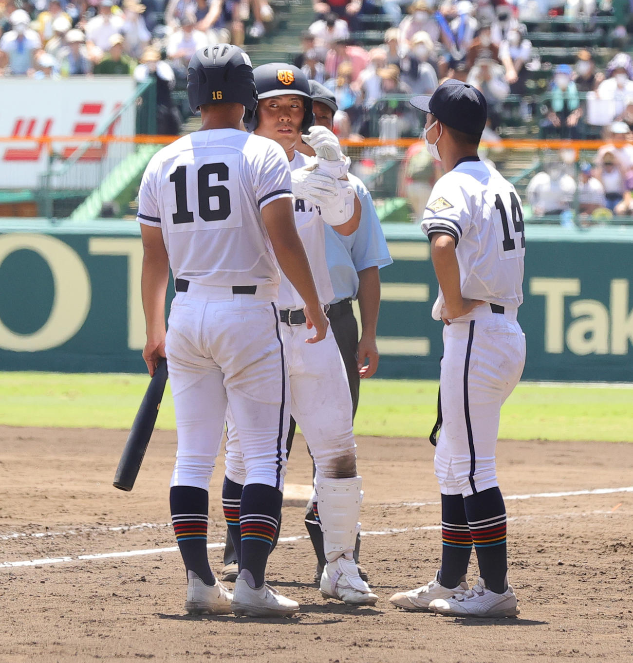 高松商対佐久長聖　8回表高松商1死一、二塁、申告敬遠と言われ一塁に向かった浅野は、取り消しとなり再びレガースなどを装着する（撮影・野上伸悟）
