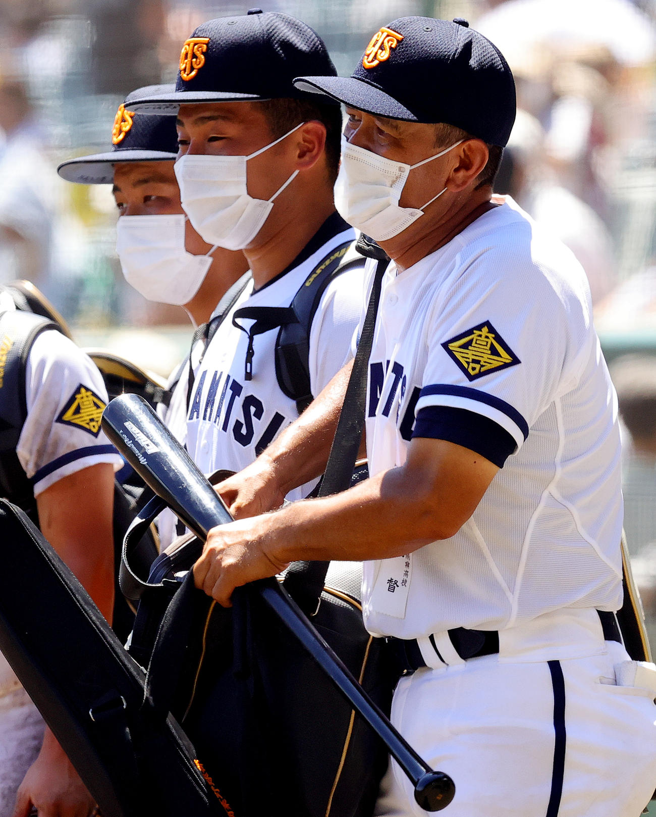 高松商対佐久長聖　14－4で勝利した高松商・長尾監督（右端）は、イチロー氏から贈られたバットを手に引き揚げる。右から2人目は浅野主将（撮影・野上伸悟）