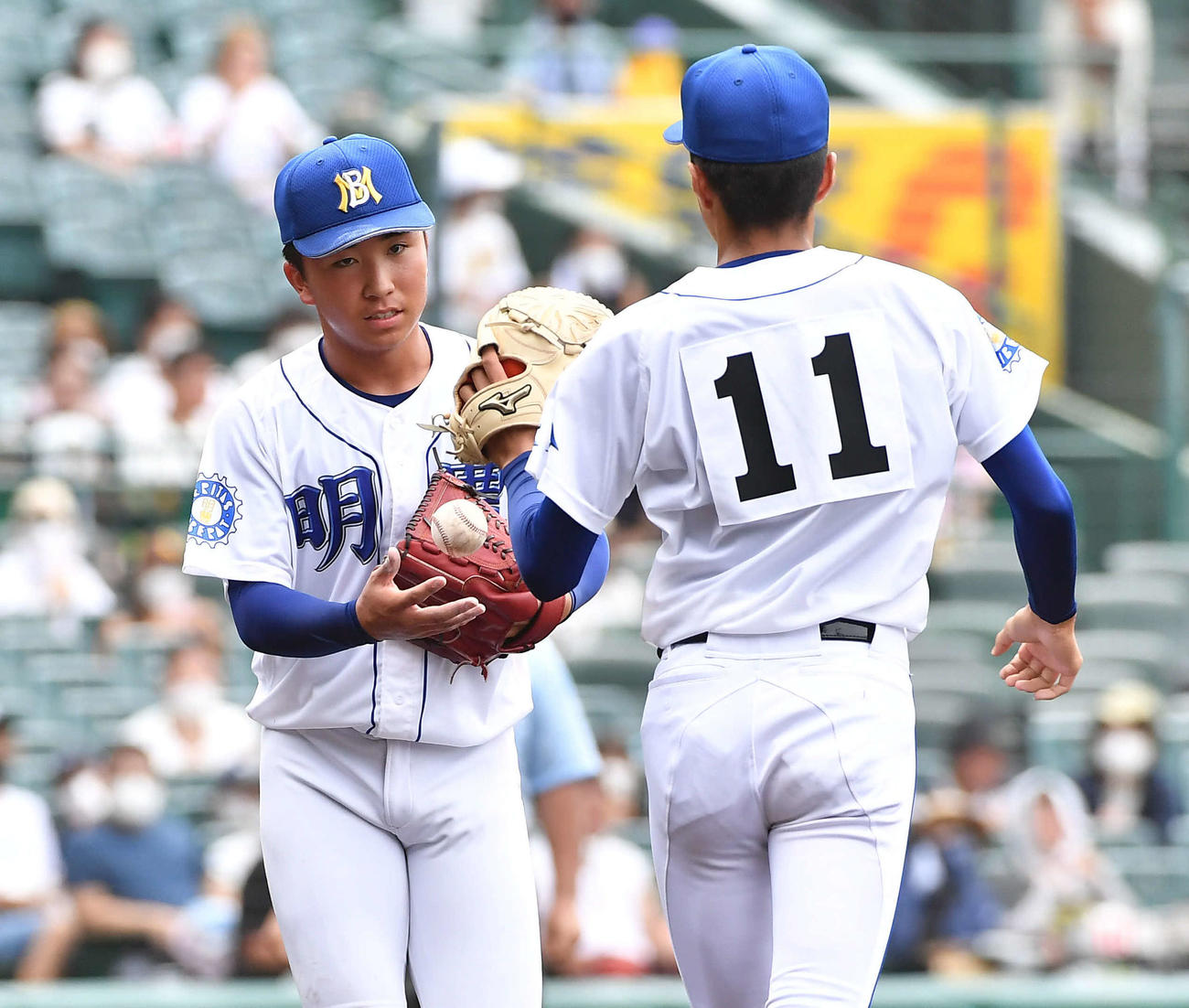 明豊対一関学院　2回裏途中降板となり、2番手の野村（右）にボールを渡す明豊中山（撮影・岩下翔太）