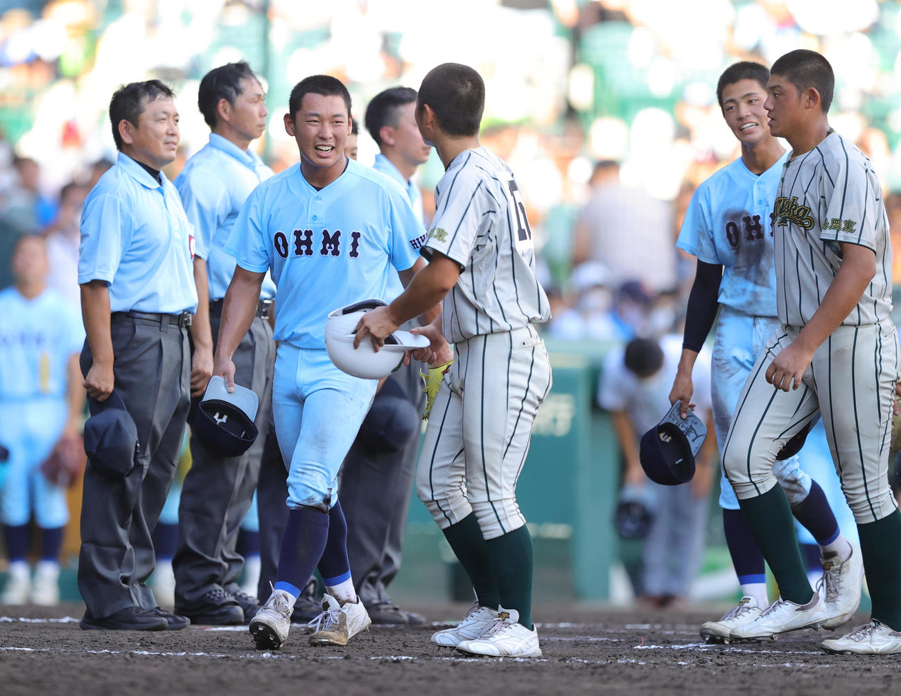 完投勝利を挙げた近江・山田主将（左端）は、鶴岡東・佐藤叶主将と笑顔で言葉を交わす（撮影・野上伸悟）