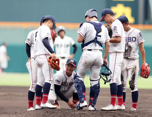 大阪桐蔭対聖望学園 2回、聖望学園の投手・岡部(左から3人目)はマウンドで靴ひもを結ぶ(撮影・上山淳一)