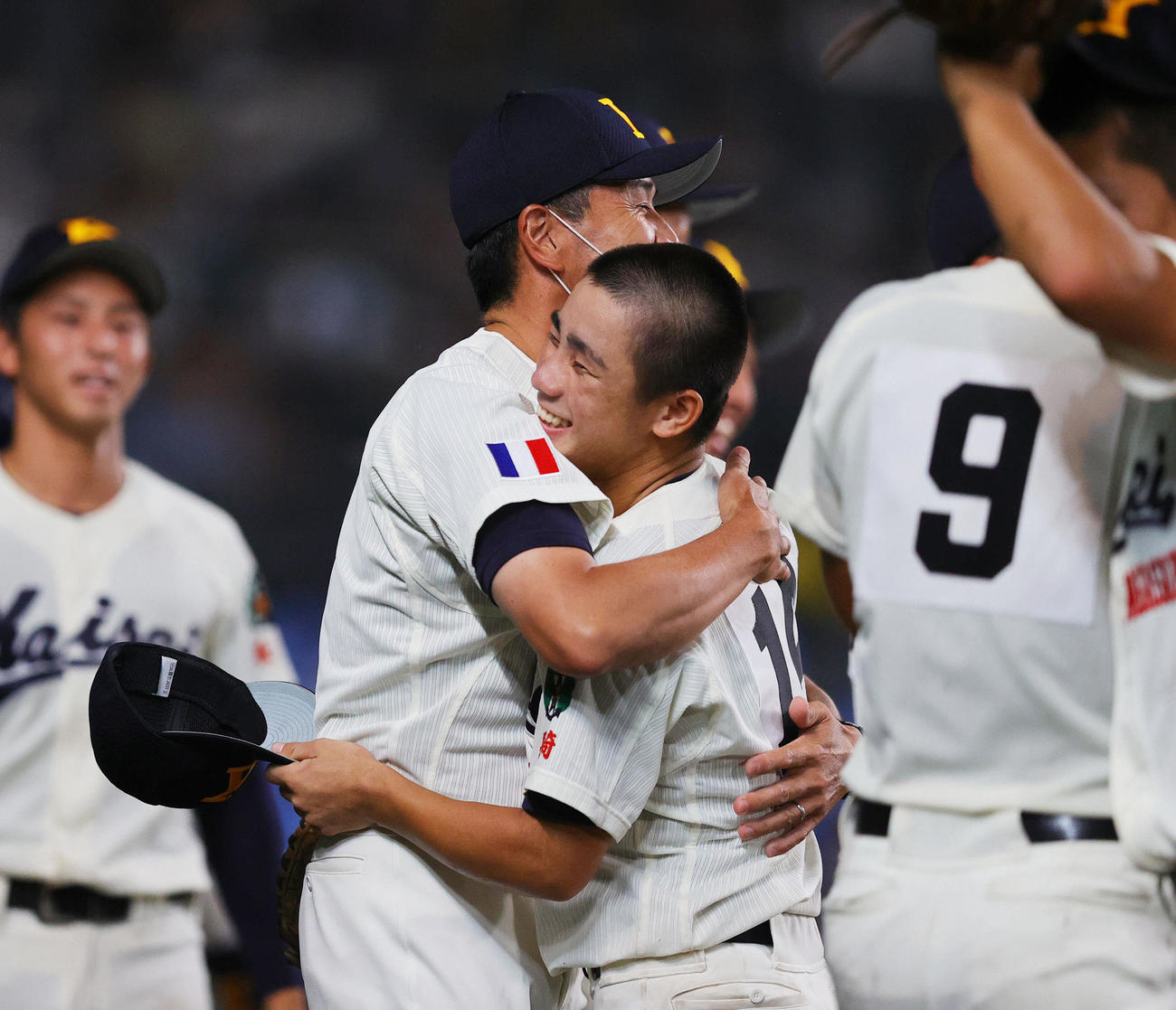 22年8月12日、海星対天理　8回裏天理2死満塁、戸井の二飛を好捕した峯（右）を抱き締める加藤監督