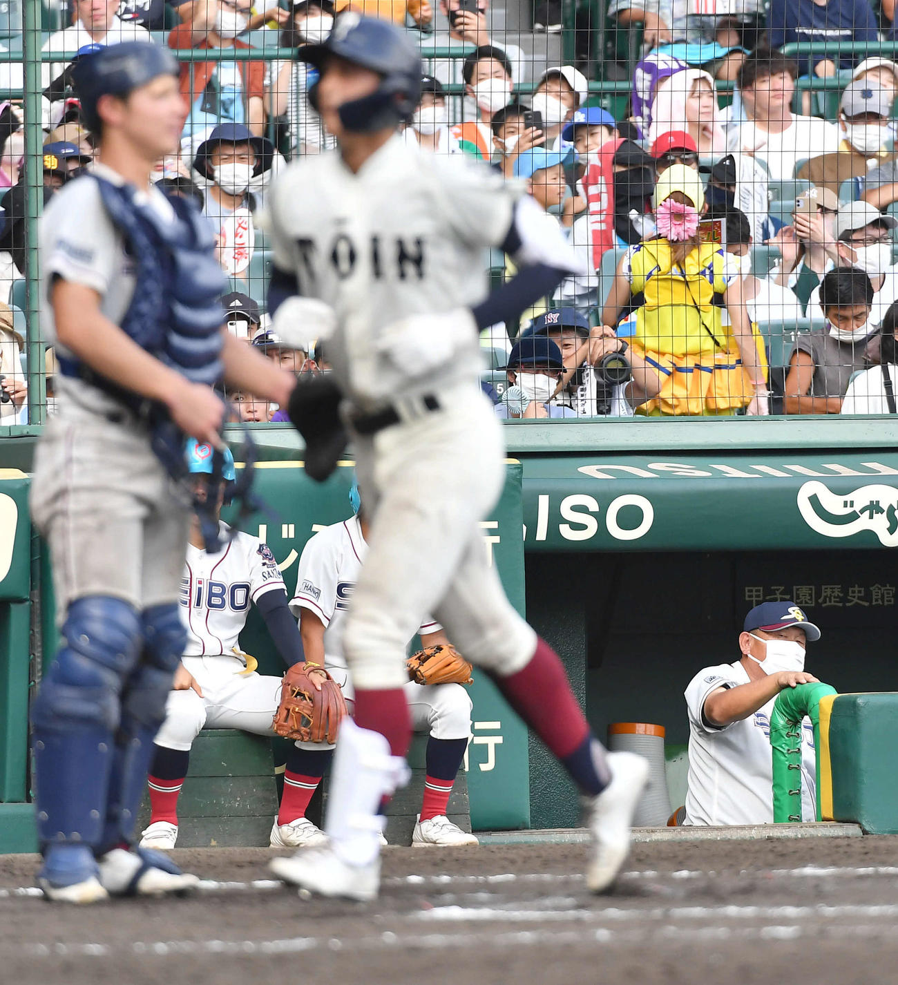 大阪桐蔭対聖望学園　9回表大阪桐蔭1死二塁、松尾（手前）に左越え2点本塁打を打たれ、厳しい表情を見せる聖望学園・岡本監督（右）（撮影・岩下翔太）