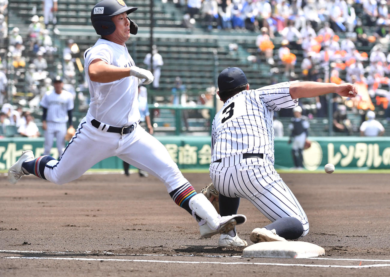 九州国際大付対高松商　1回裏高松商無死、二塁内野安打で出塁する浅野、右は九州国際大付一塁手の佐倉（撮影・岩下翔太）