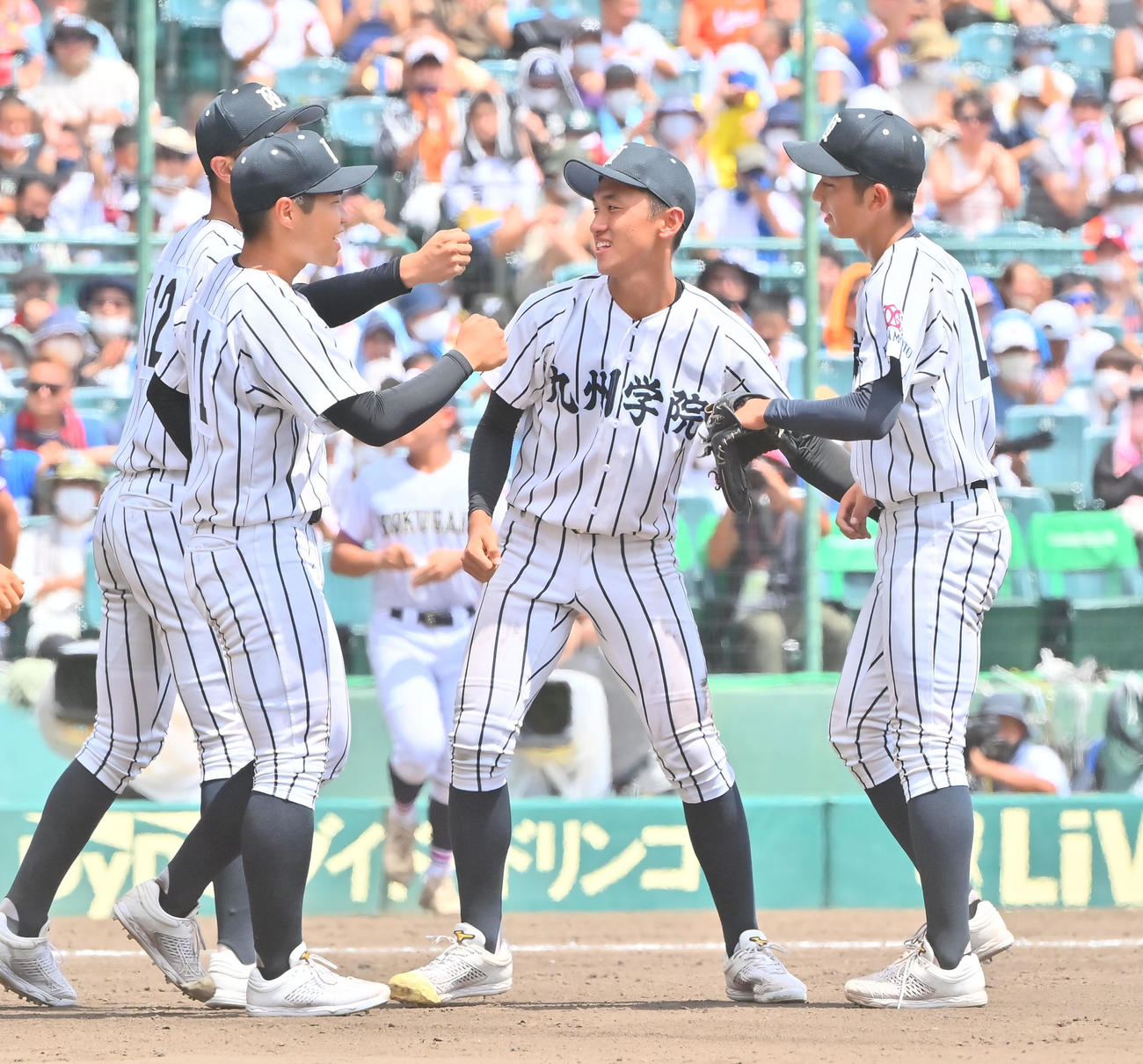 国学院栃木対九州学院　国学院栃木を完封しナインとタッチする九州学院・直江（撮影・和賀正仁）