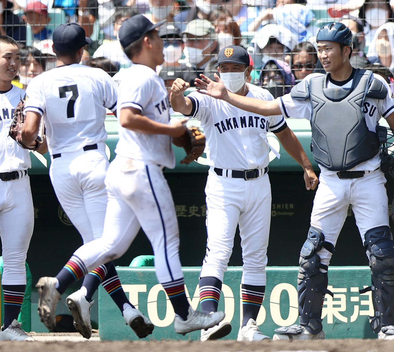 高松商対近江　3回裏近江2死満塁、高松商の長尾監督（右から2人目）は好送球でピンチを救った左翼手井桜（7）を出迎える（撮影・上山淳一）