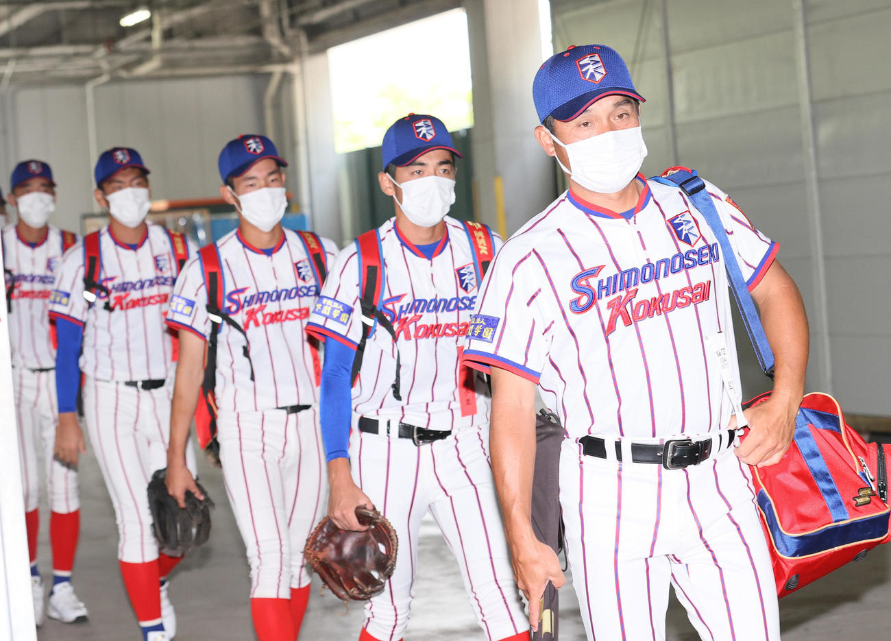 仙台育英対下関国際　決勝戦に向け、球場入りする下関国際の坂原監督（手前）らナイン（撮影・上山淳一）