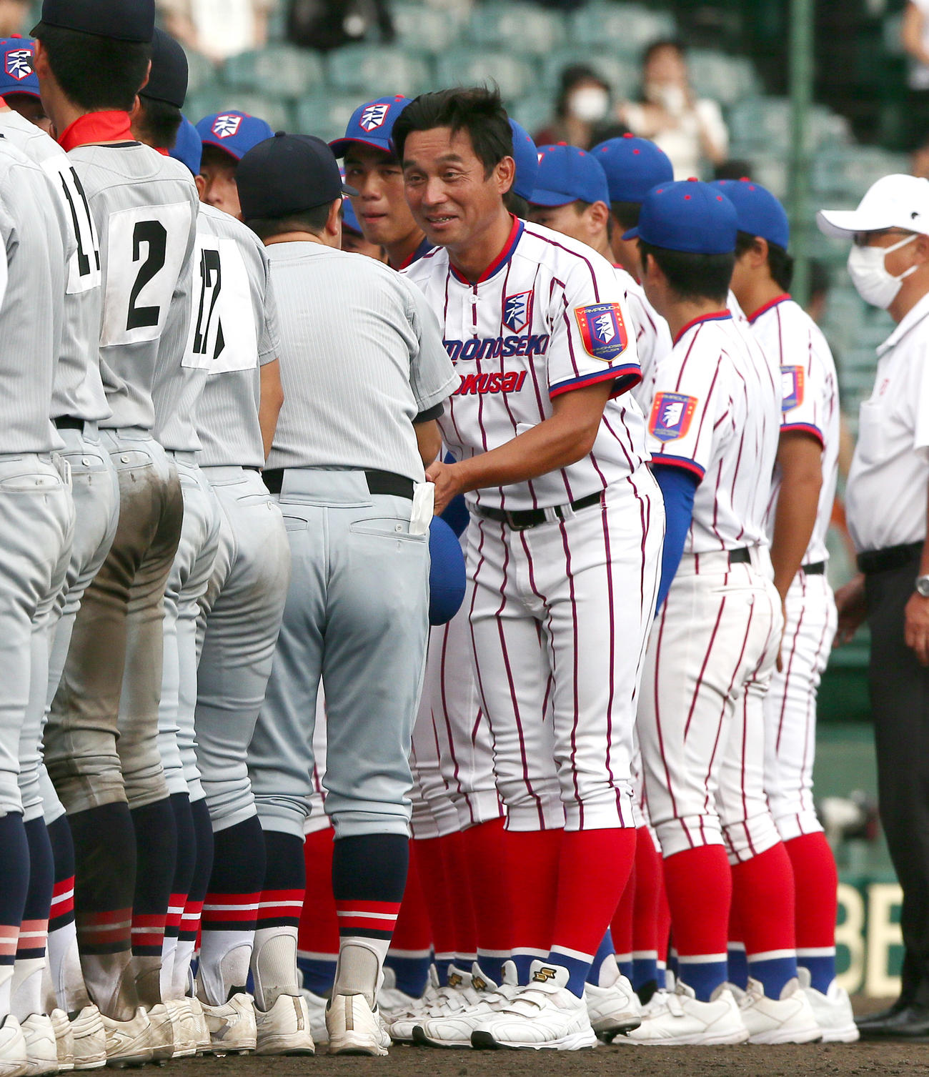 仙台育英対下関国際　試合を終え、下関国際の坂原監督（右）は仙台育英の須江監督と握手を交わす（撮影・上山淳一）