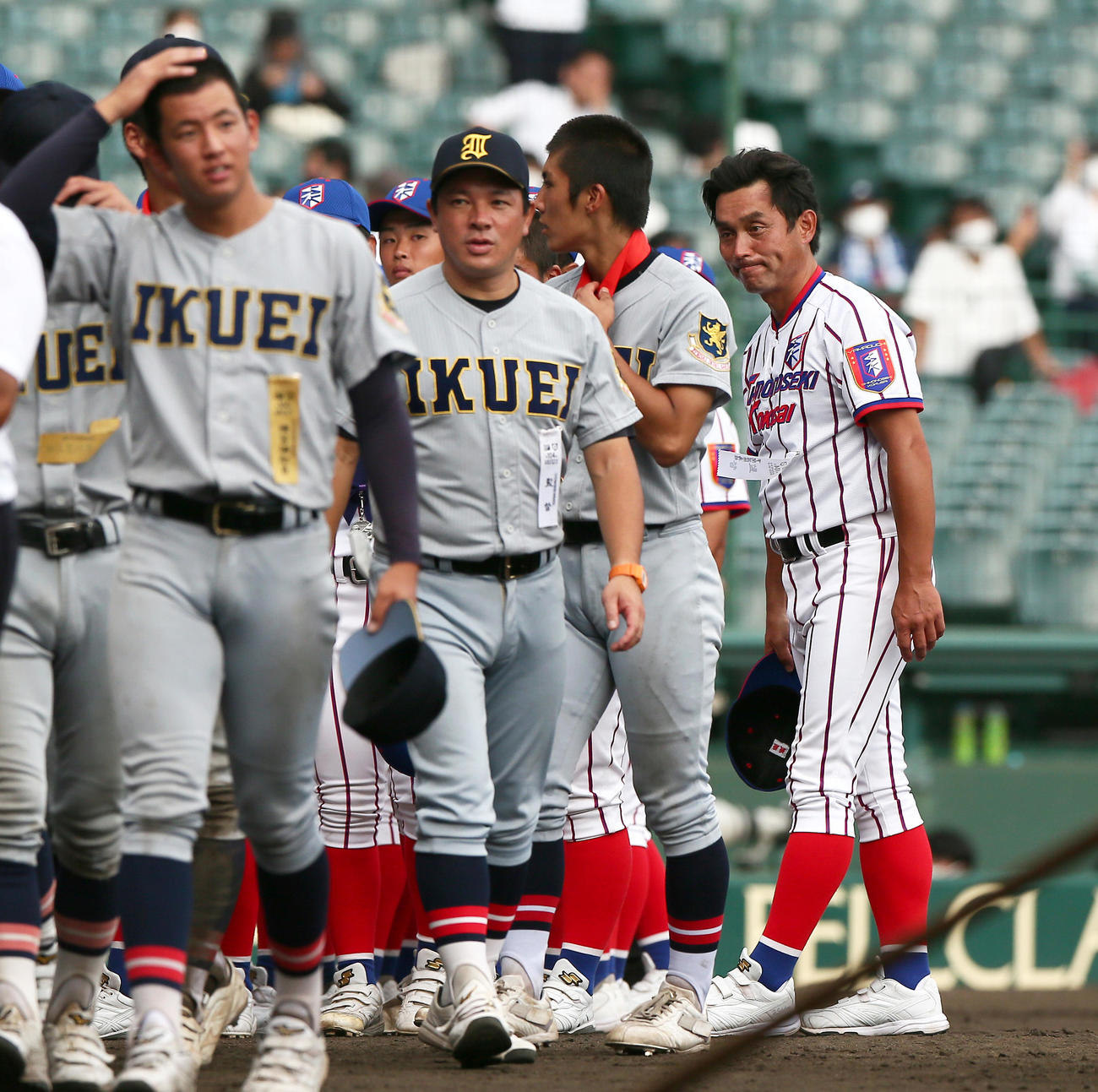 仙台育英対下関国際　記念撮影を終えあいさつする下関国際の坂原監督（右）。左から2人目は仙台育英の須江監督（撮影・上山淳一）