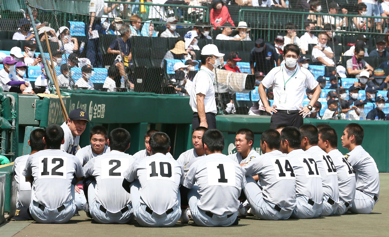仙台育英対下関国際　試合前、ベンチ前で仙台育英の須江監督の話を聞く選手たち（撮影・上山淳一）