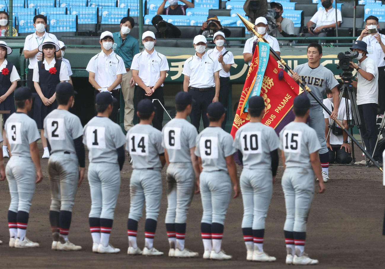 仙台育英対下関国際　仙台育英・佐藤主将（右）は優勝旗を手にナインの整列に戻る（撮影・上田博志）