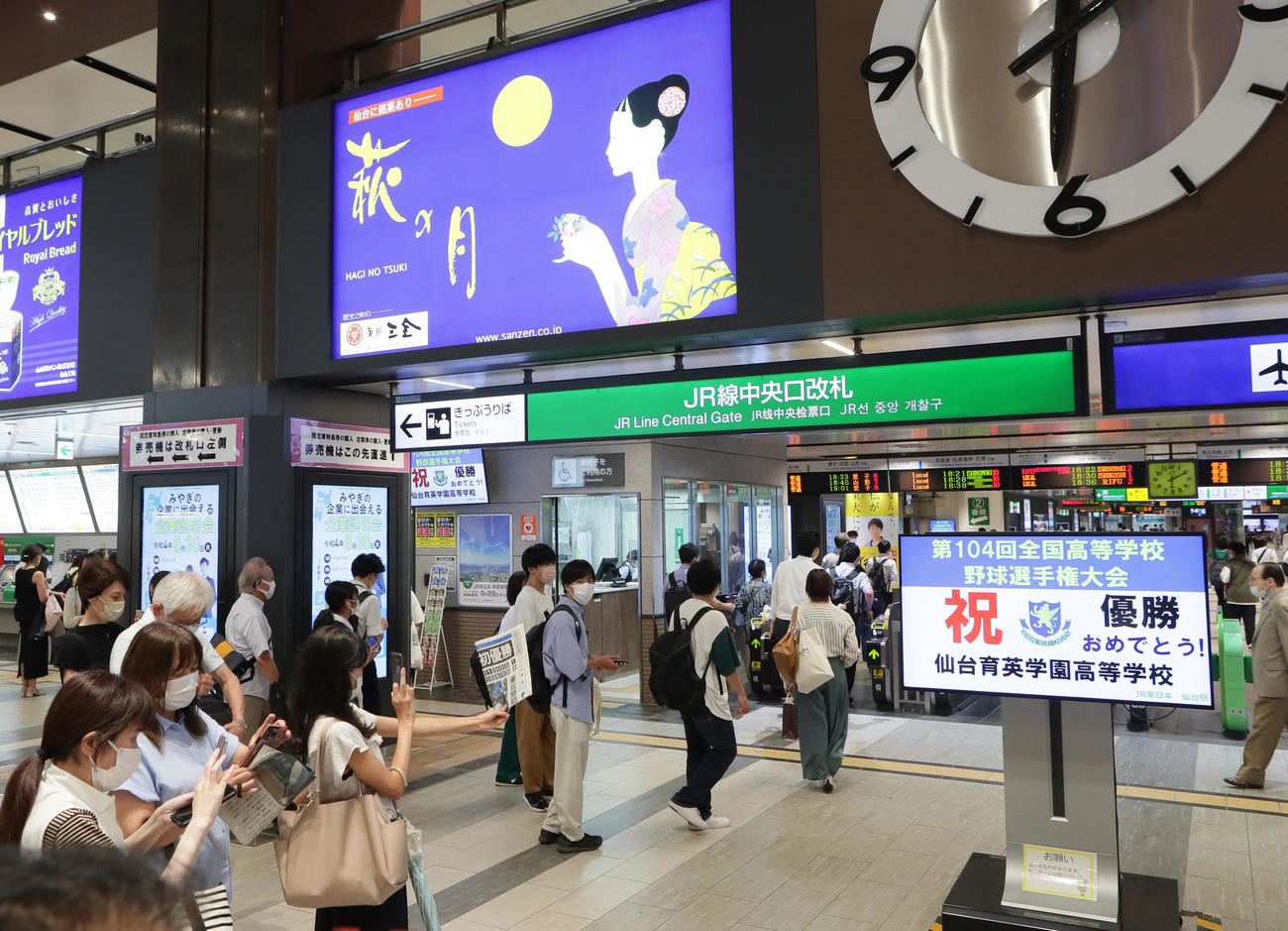 仙台育英優勝を祝う画面を記念撮影する人たち（撮影・足立雅史）