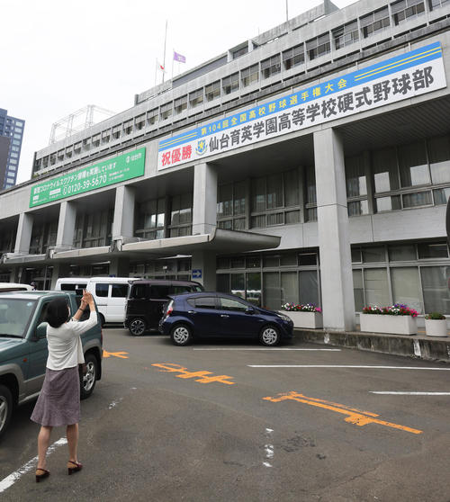 仙台市役所の仙台育英の甲子園初優勝を祝う横断幕を記念撮影する人（撮影・足立雅史）